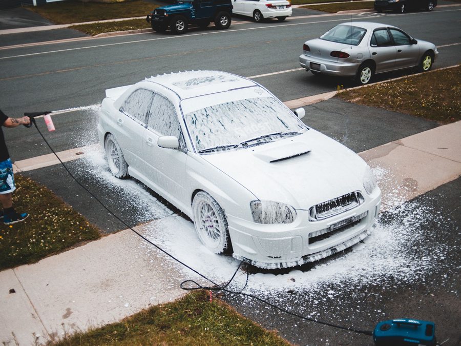 Foam wash performed on a car in a driveway