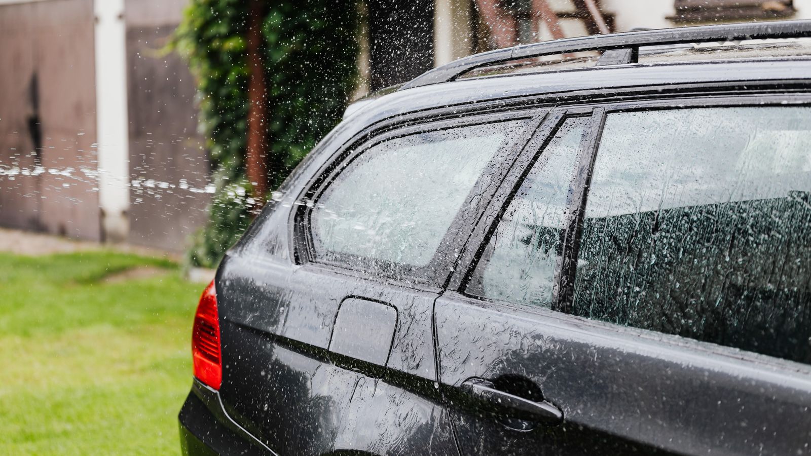 Mobile detailer washing a car in a customer's driveway