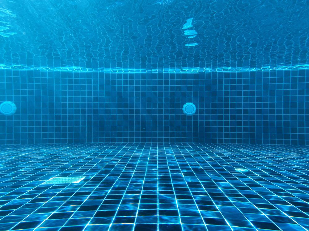 Clean blue pool tile viewed beneath the water
